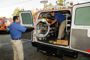 Technicians gathering service supplies from a service van